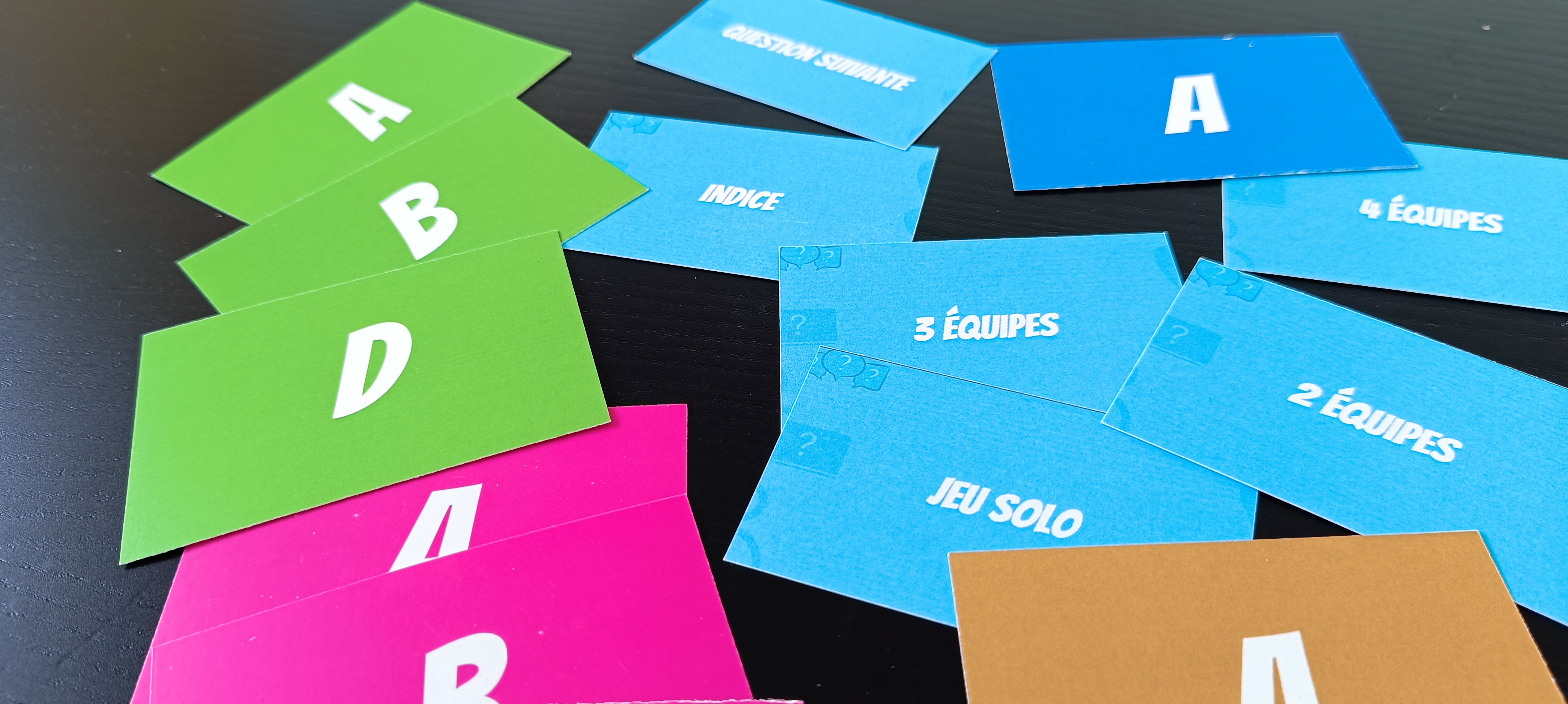 Les cartes-réponses A, B, C, D et les cartes clé du jeu, une couleur par équipe