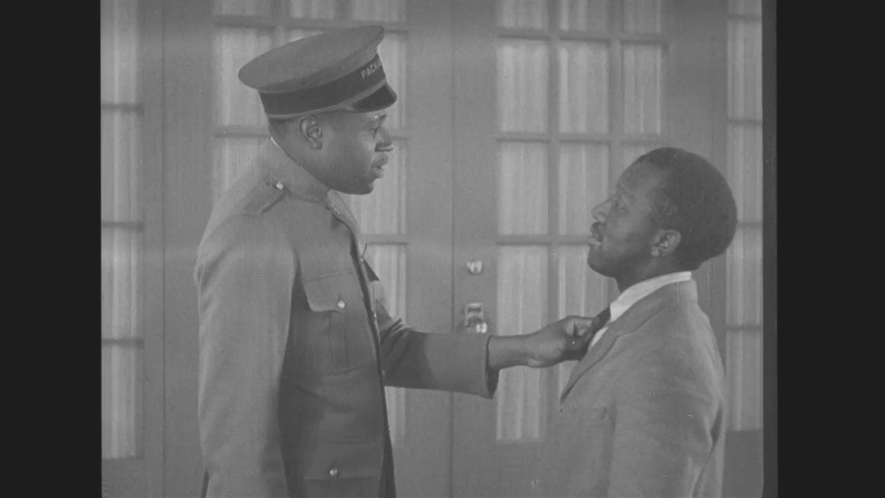 Deux hommes dans un vieux film, l'un en uniforme saisit l'autre par le col