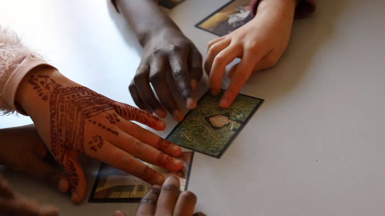 Des mains posent une carte image sur la table